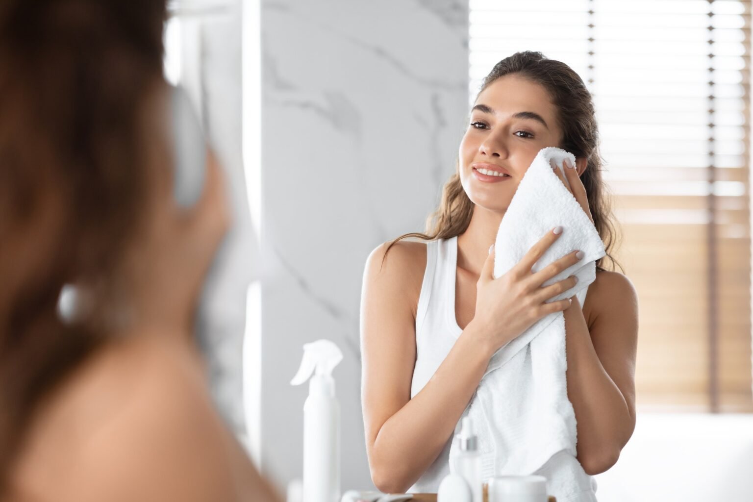 Lady Drying Face With Towel During Morning Routine In Bathroom