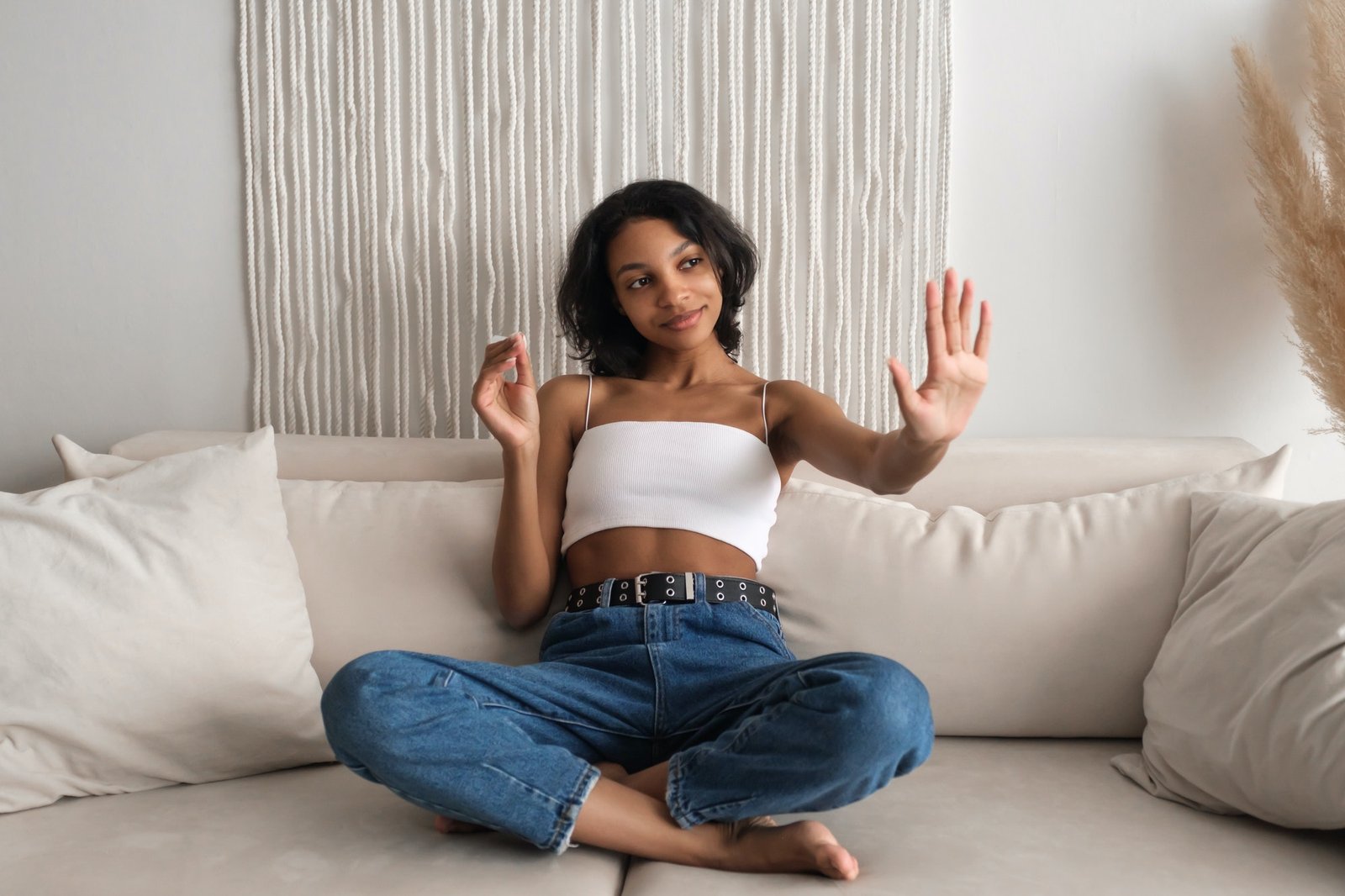 Happy beautiful woman using nails lime sitting on sofa at home.Bodycare concept. Leisure